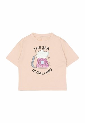Lyserød T-shirt med korte ærmer lavet af blødt stof med en illustration af en telefon med skyer og teksten "HAVET RINGER."