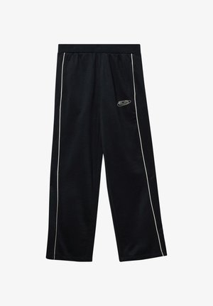 Melnas sporta bikses, izgatavotas no mīksta auduma, ar baltām sānu joslām un mazu logotipu kreisajā gurnā. Elastīgs jostasviets, lai nodrošinātu komfortu.