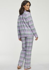 Plaid pajama set in lavender, green, and gray. Long-sleeve button-up shirt with a relaxed fit and matching pants. Soft fabric, straight leg.