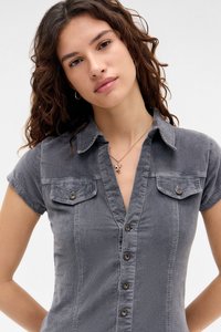 Svijetlosiva košulja s kratkim rukavima, s ovratnikom, dva džepa na prsima i metalnim gumbima; teksturirana tkanina.