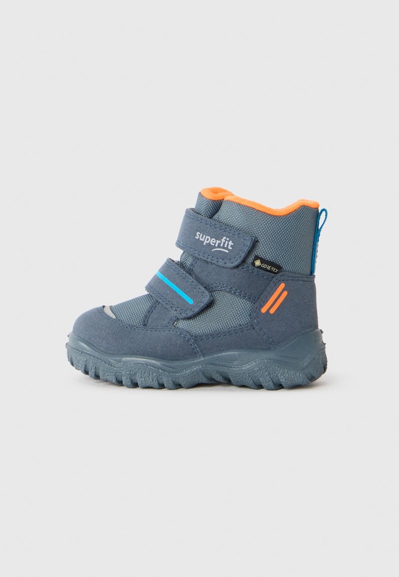 Botte d'hiver pour enfant de couleur gris foncé et orange, dotée de deux sangles Velcro, d'une semelle robuste, d'une boucle bleue et d'une étiquette Gore-Tex pour l'imperméabilité.