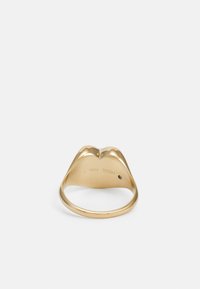 Goldfarbener Ring mit einem lippenförmigen Design, glatter Oberfläche, geschwungenen Kanten und Innengravur "Fossil Steel" in Größe 7.