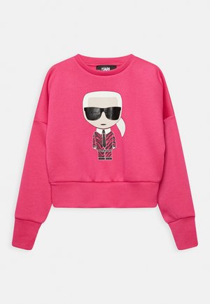 Roze, cropped sweatshirt van zacht materiaal met een cartoonontwerp van een oversized figuur in een zonnebril en een gestreept pak.