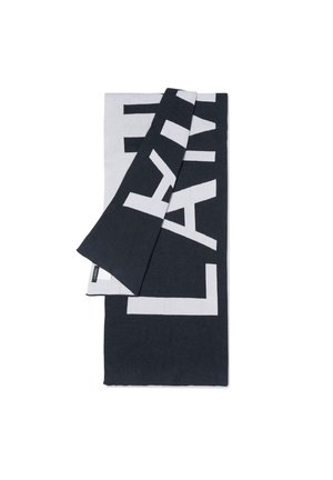 Textil alb-negru cu litere mari, îndrăznețe. Materialul pare moale, cu o textură netedă și un design stratificat.