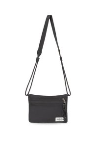 Černá látková crossbody taška s nastavitelným popruhem, která má několik zipových kapes a značkovou nálepku. Hladký povrch a obdélníkový tvar.