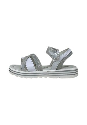 Sandali per bambini argento e bianchi con cinturini glitterati, chiusure in velcro e una suola texturizzata e flessibile; progettati per il comfort e la stabilità.