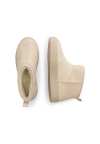 Beige suède enkellaarzen met een zachte binnenkant, eenvoudig ontwerp en rubberen zool met horizontale groeven voor grip.