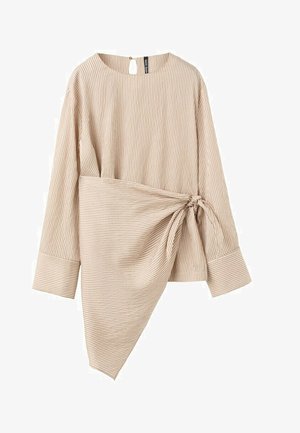 Bež dugi rukav rebrasti top s asimetričnim omotačem vezanim u čvor oko struka i širokim manšetama.