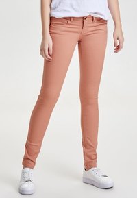Jeans ajustados cortos de color rosa claro, fabricados en denim elástico, con un diseño clásico de cinco bolsillos y cierre de cremallera con botón.