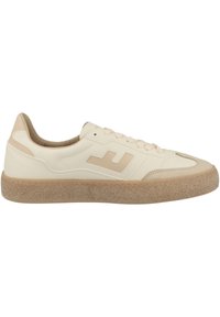 Beige sneakers with a textured rubber sole, smooth leather upper, and tonal accents. Features a logo on the side and flat laces.