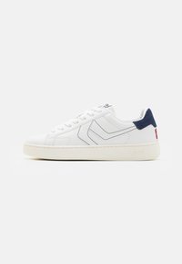 Sneaker bianca con accenti blu navy, materiali in pelle e tessuto testurizzati, punta rotonda, suola piatta e dettagli di cucitura a contrasto sui lati.