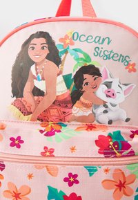 Rosa ryggsäck med ett blommönster, tecknade figurerna Moana och ett barn med en gris, samt texten "Ocean Sisters" i aquafärg.