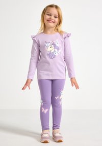Lilla langærmet skjorte med flæser på ærmerne, med en enhjørning og sommerfugle. Matchende lilla leggings med lignende motiver.