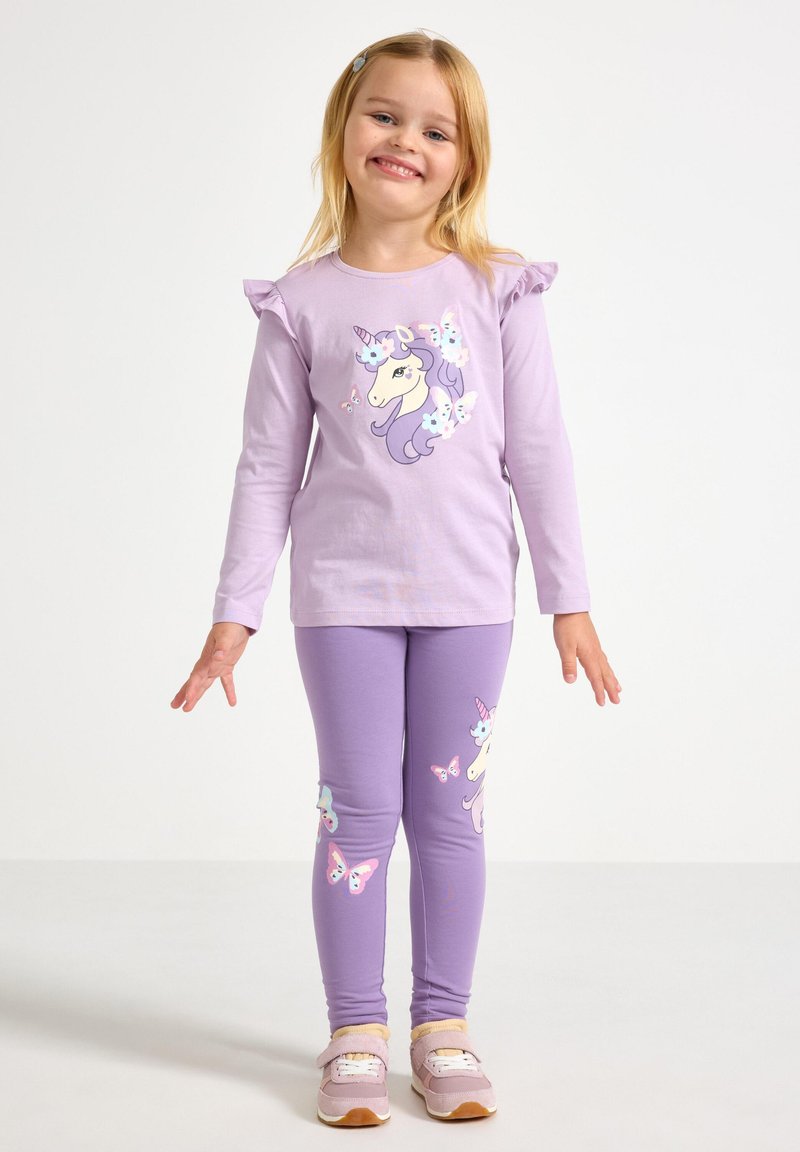 Lilla langærmet skjorte med flæser på ærmerne, med en enhjørning og sommerfugle. Matchende lilla leggings med lignende motiver.