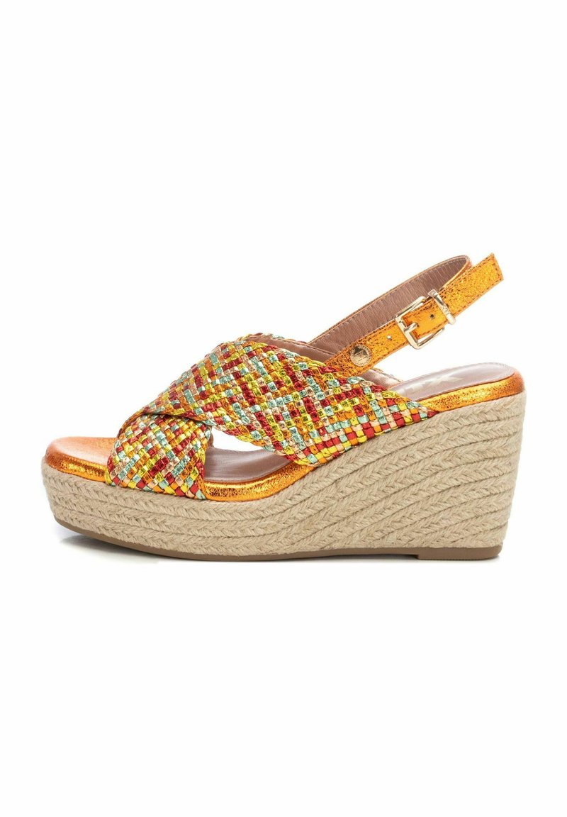 Sandalia cuña con tiras metálicas naranjas que presentan un patrón multicolor tejido. Tacón de cuña envuelto en yute, plantilla metálica suave.