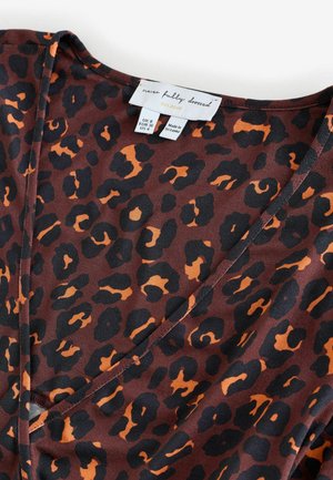 Brauner Stoff mit einem schwarzen und orangefarbenen Leopardenmuster. V-Ausschnitt-Design mit glatter Textur und einem Etikett, das Größe und Marke angibt.