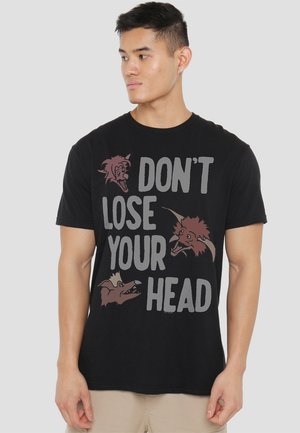 Black cotton t-shirt featuring graphic text "DON'T LOSE YOUR HEAD" and three stylized animal heads in red and gray. Short sleeves, casual fit.
