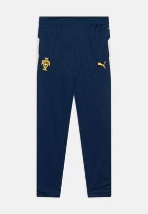 Pantalons de sport navy en tissu respirant. Comprend des logos jaunes, une taille élastique et des poches latérales avec des accents blancs.