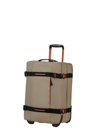 Equipaje con ruedas beige con un exterior texturizado, acentos rojos, correas negras y cremalleras dobles, que cuenta con un mango retráctil y ruedas que giran.