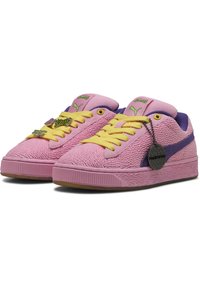 Rosa sneakers med struktureret gummioverdel, gule snørebånd og lilla accenter. Har en mærkat og branding på tungen. Flad sål.
