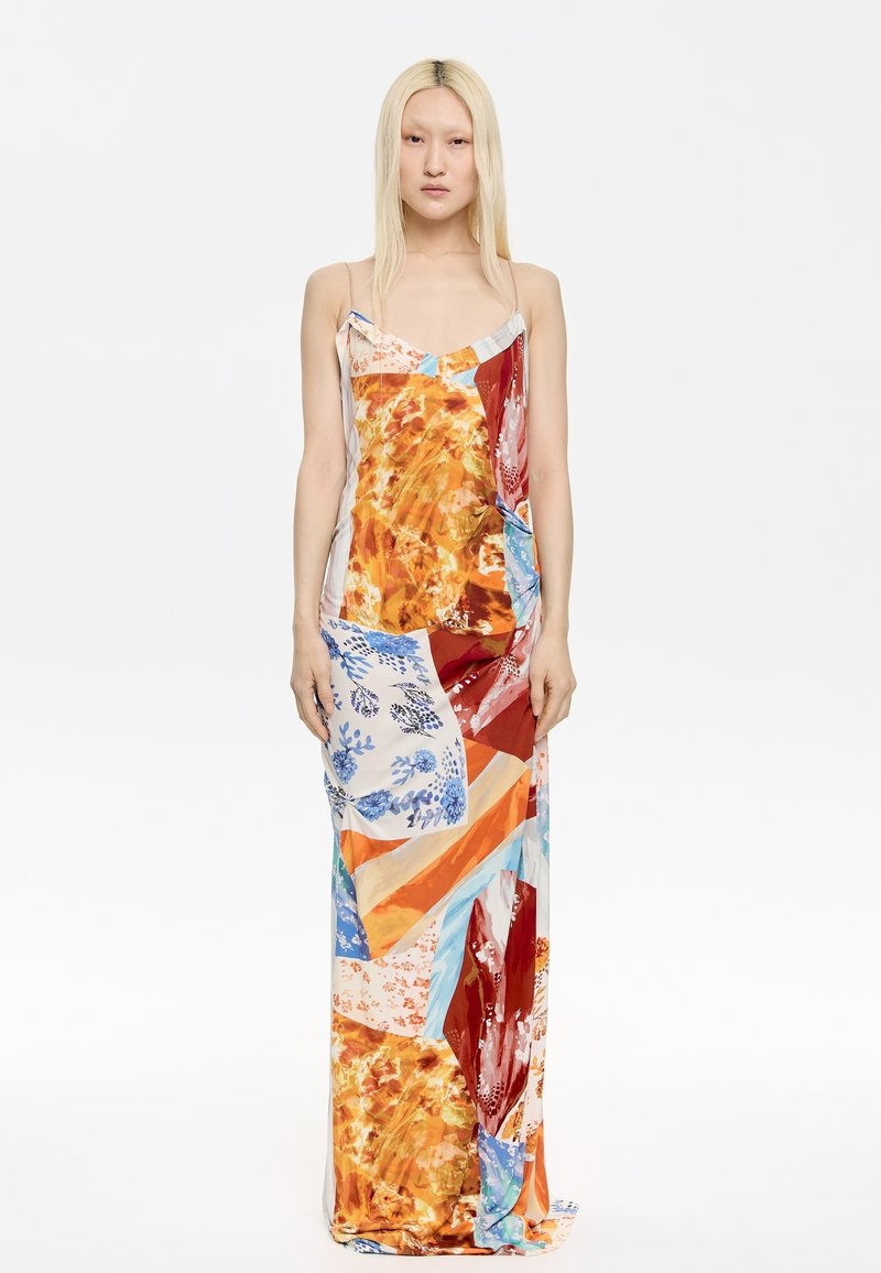 Maxi-jurk met een kleurrijke patchwork van oranje, blauw en rode stoffen met bloem- en abstracte patronen, gemaakt van lichtgewicht materiaal.