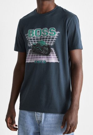 Dunkelblaues Baumwoll-T-Shirt mit einem grafischen Design eines Retro-Motorrads und dem Wort "BOSS" in Grün, mit einem Gittermuster-Hintergrund.
