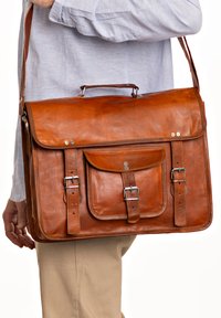 Brun læder messenger taske med låg, to front spænder og et håndtag på toppen. Har en frontlomme med tryklås.