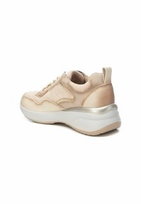Zapatillas beige con parte superior de ante y cuero texturizado, detalles en dorado, suela blanca acolchada y cuello acolchado para mayor soporte.