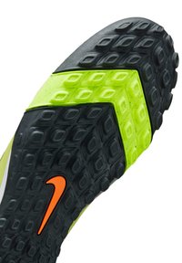 Nike fodboldstøvlesål i sort og neongrøn med et tekstureret mønster og et orange logo. Har en særpræget form til trækkraft.