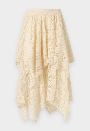 Jupe longue asymétrique en dentelle crème avec ourlet festonné et taille élastique, présentant des motifs floraux et tourbillonnants sur tout le tissu.