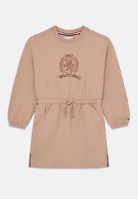 Abito felpa beige con vita elastica, maniche lunghe, colletto a girocollo e emblema ricamato. Presenta tasche laterali e dettagli a righe sull'orlo.