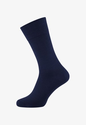 Marineblaue socke bis zur Mitte der Wade mit einem gerippten Bündchen, glatter Textur und nahtloser Spitze auf weißem Hintergrund.