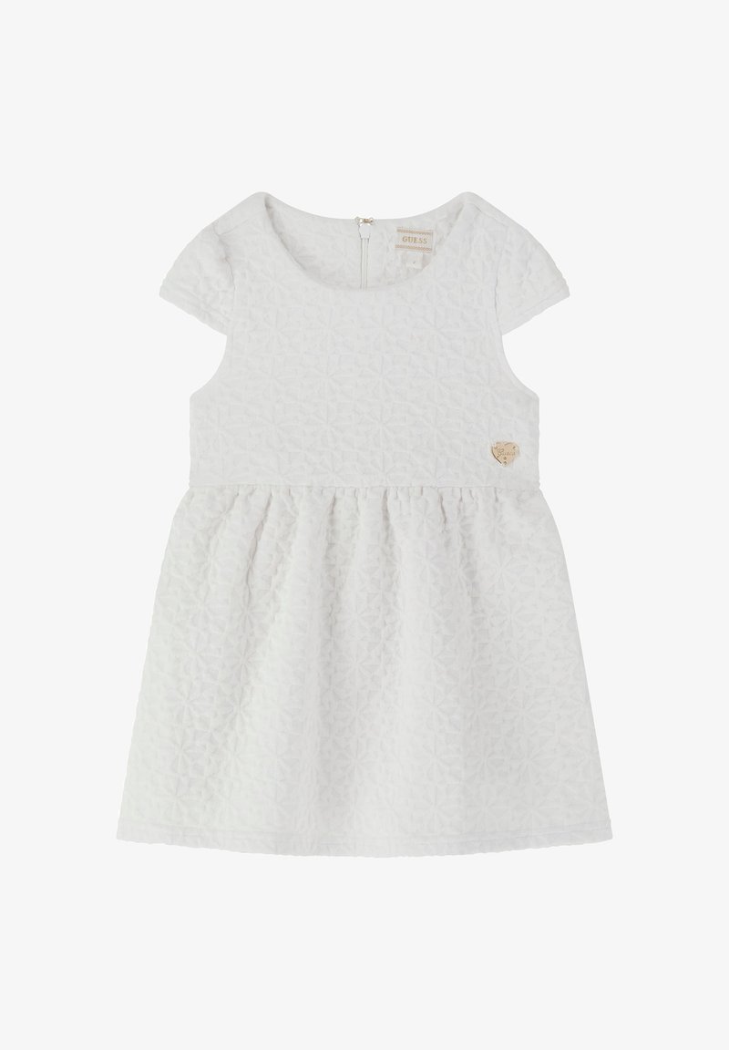 Balta kleita ar teksturētu ģeometrisku rakstu, īsām piedurknēm un saliektu svārku. Aprīkota ar aizmugures rāvējslēdzēju un mazu sirds logo uz krūšu daļas.