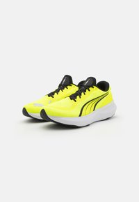 Zapatillas deportivas en amarillo neón con detalles en negro y parte superior de malla, que cuentan con un collarín acolchado, diseño de cordones y una suela blanca ligera.