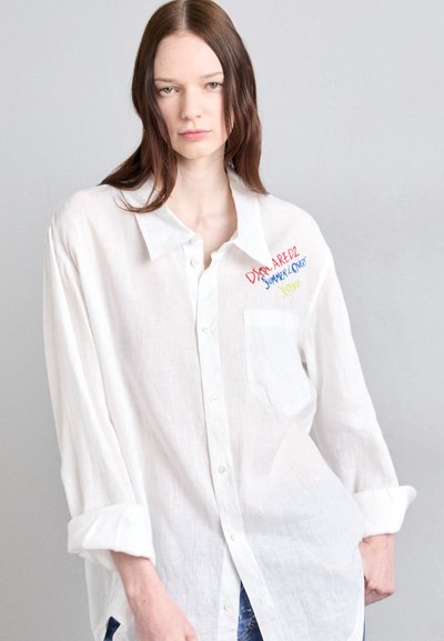 Biela ľanová košeľa s gombíkmi, ktorá má ľavú náprsné vrecko a farebný vyšitý nápis "DSQUARED2 SUMMER LOVERS Yolo."