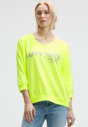 Neon-gelbes Sweatshirt mit V-Ausschnitt, lockerer Passform und Dreiviertelärmeln. In Silber gedruckter Text mit der Aufschrift "HAPPY TIMES". Lässiges Design.