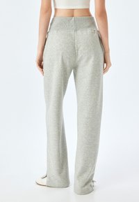 Grijze, loszittende sweatpants met een hoge tailleband. Bevat zijzakken en een zachte, gestructureerde stof.