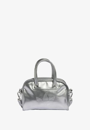 Silberne metallische Handtasche mit zwei oberen Griffen, Reißverschluss und einem geprägten Logo auf der Vorderseite. Glatte Textur und kompaktes Design.