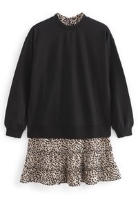 Felpa nera a maniche lunghe indossata sopra un vestito a strati con un tessuto beige e un motivo a stampa leopardata nera.