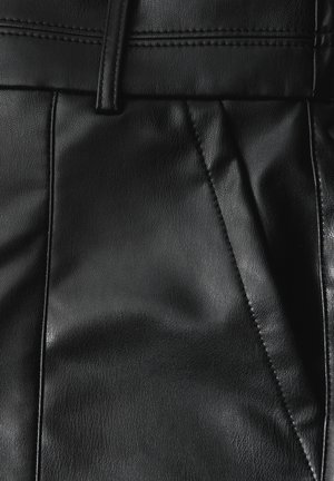 Pantalons en cuir noir avec une texture lisse, présentant des plis avant et un design ajusté. Détails cousus le long de la taille.
