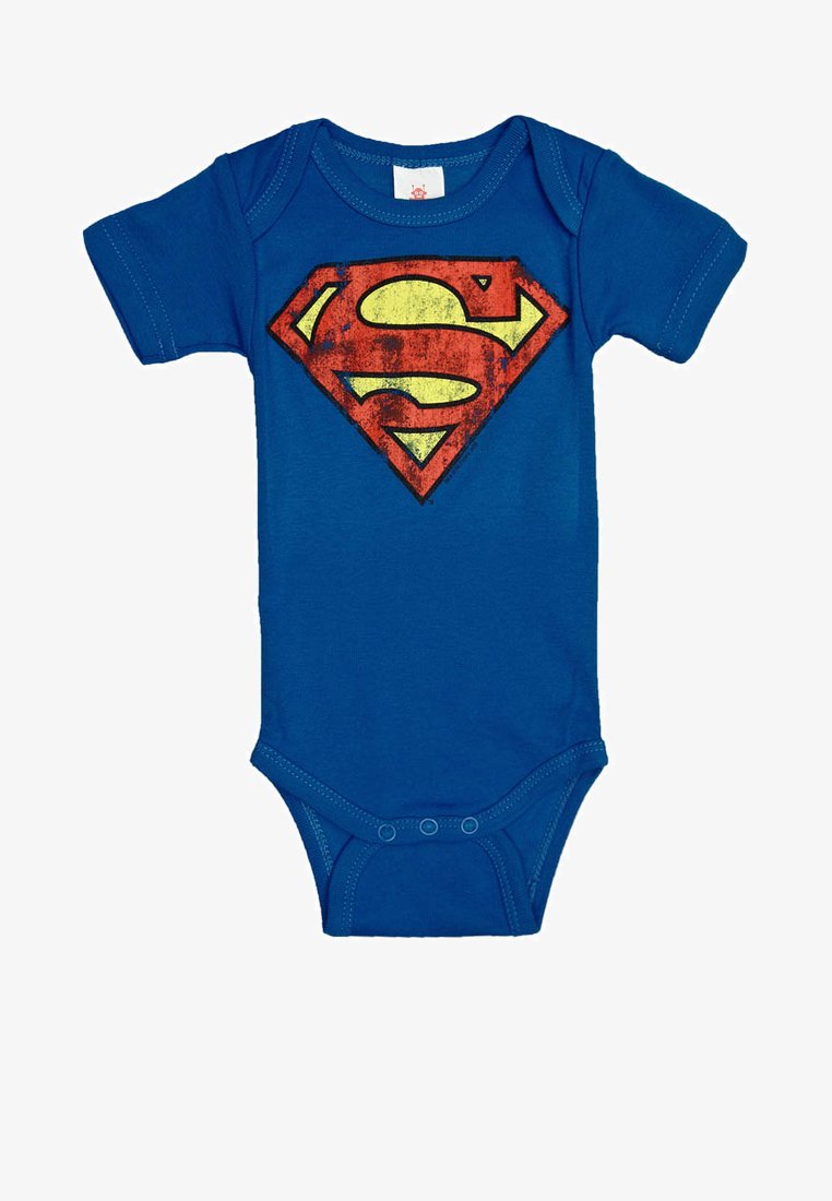 Blaues Babystrampler mit kurzen Ärmeln und einem abgenutzten roten und gelben Superman-Logo auf der Brust, Druckknöpfe am Boden.