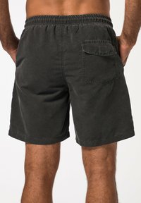 Zwarte katoenen shorts met elastische tailleband, achterzak en een casual pasvorm. Kenmerkt zich door een gestikt zoom en een zachte textuur.