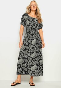 Maxikleid in Schwarz mit weißen Paisleymuster, ausgestattet mit einem runden Halsausschnitt, kurzen Puffärmeln und einem elastischen Bund für eine taillierte Form.
