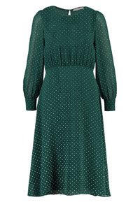 Robe verte à pois avec manches longues, taille froncée, silhouette fluide et tissu lisse. Caractérisée par un col rond et une ouverture keyhole au dos.
