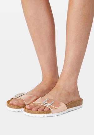 Sandales à glissière roses avec une large sangle et une boucle en argent, semelle en liège et semelle en caoutchouc blanc. Matériau lisse et design plat.