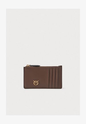 Porte-cartes en cuir marron avec fermeture éclair, comportant quatre fentes pour cartes et un détail logo doré à l'avant. Texture lisse.