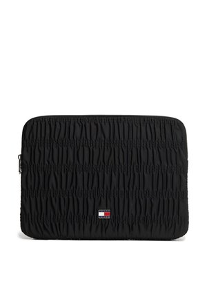 Schwarze gesteppte Laptop-Hülle mit horizontaler Raffung und einem kleinen rechteckigen Tommy Jeans-Logo-Patch, zentral nahe dem unteren Rand.