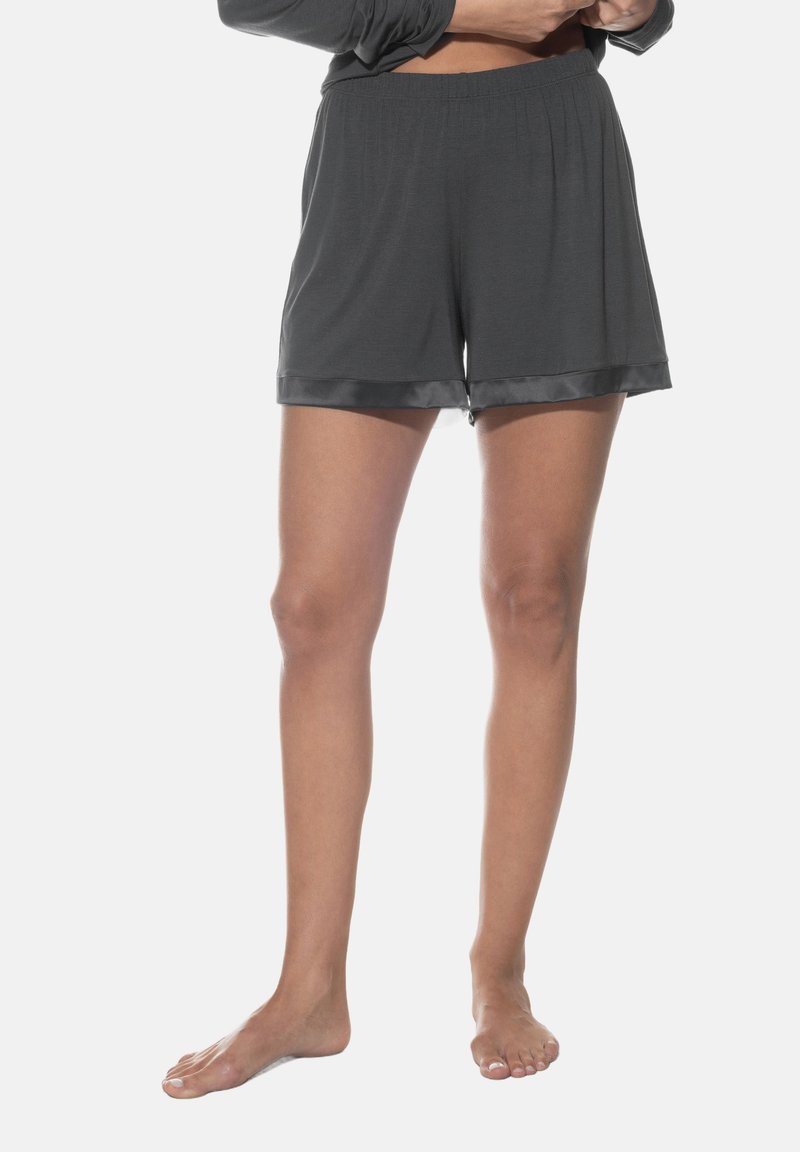 Grijze relaxte shorts gemaakt van zachte stof, met een gladde satijnen zoom. De elastische tailleband zorgt voor gemakkelijk draagcomfort. Modelle met blote voeten.
