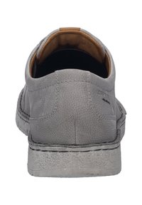 Šedé kožené slip-on boty s texturovaným povrchem, kontrastním hnědým vnitřkem a bílou prošívanou podrážkou. Obsahují minimalistické designové detaily.