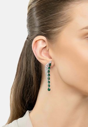 Green gemstone and clear crystal drop earrings with a cascading design, featuring teardrop shapes and a silver setting.